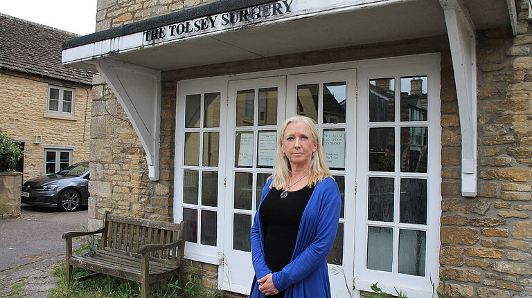 Roz Savage MP standing in front of Sherston Surgery looking disappointed