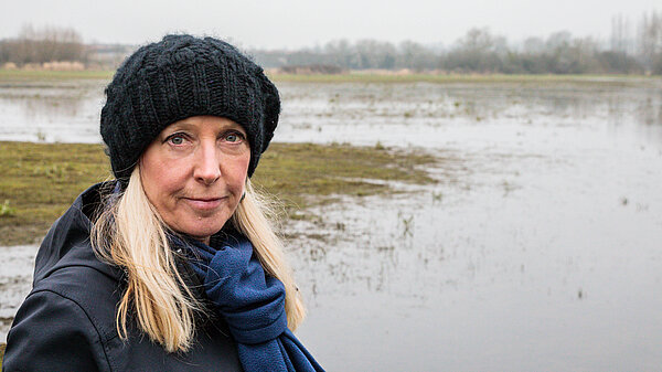 Roz Savage MP with flooding behind her in the South Cotswolds